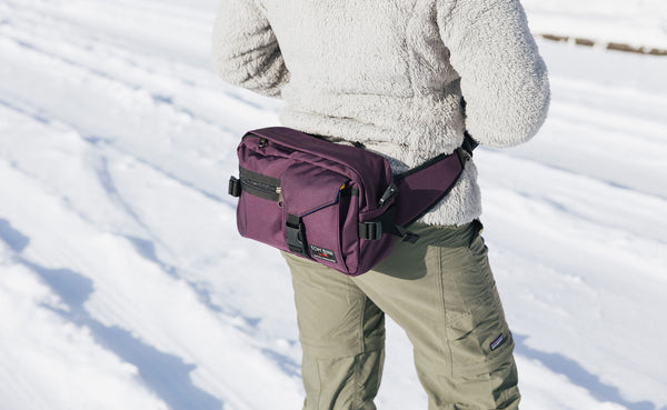 Person wearing the LPD in Aubergine as a waist pack.
